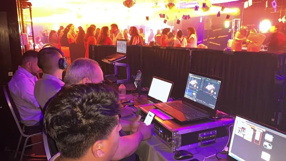 Operadores con notebooks en el puesto de control durante una fiesta