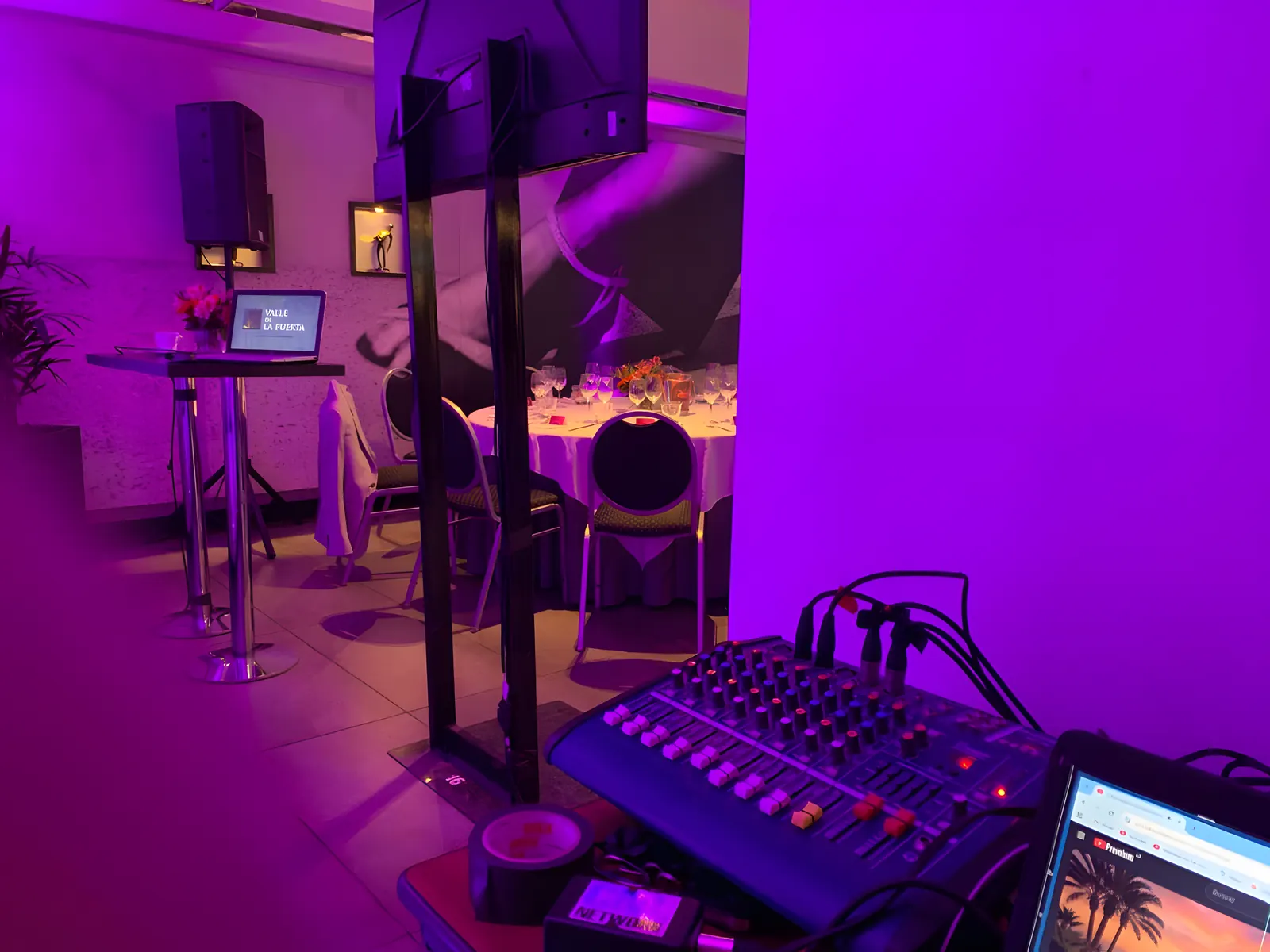 Consola de sonido y parlante en un salón iluminado en magenta
