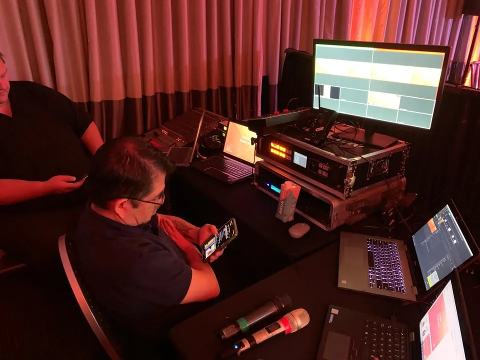 Operador con switcher de video y notebooks en el puesto de control